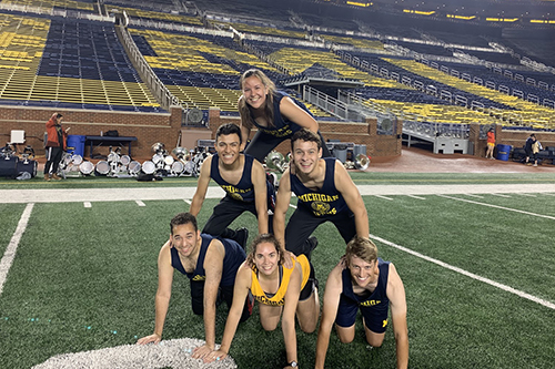 group of students doing the pyramid on the field of the Big House